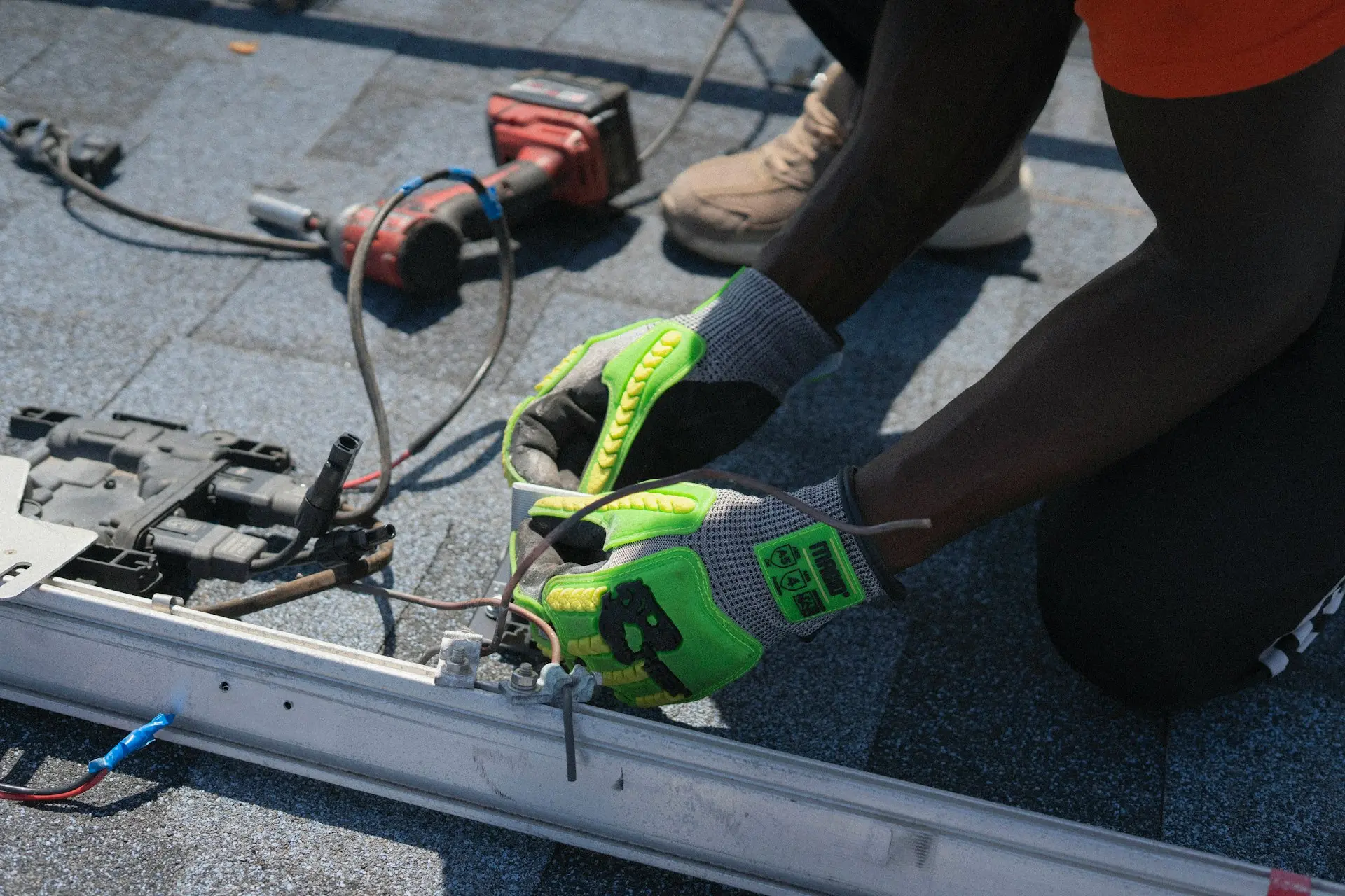 Worker installs electrical components on a roof.
